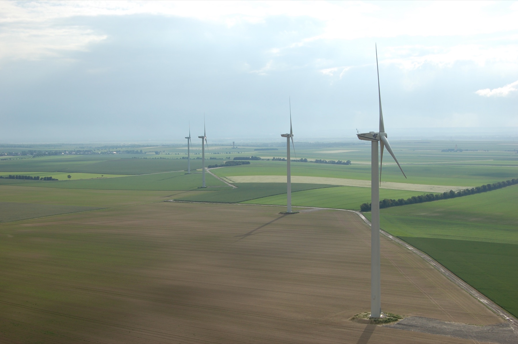 Aerial view of wind turbines across agricultural fields